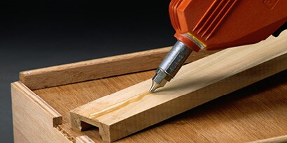Schmelzklebstoff beim Auftrag auf Holz
