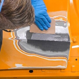 Techniker trägt eine zweite Schicht 3M™ Epoxidharz Zinnersatz-Spachtelmasse auf, um die Delle auszufüllen 