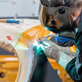 Person beim Schweißen von Karosserieteilen