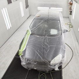 Ein Auto in einer Lackierkabine im forcierten Trocknungsprozess