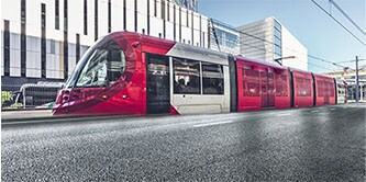 Moderner Zug mit schwarzer und roter Folierung in einem Bahnhof
