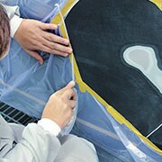 Zuschneiden der Abdeckfolie um den Reparaturbereich