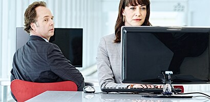 Visueller Hacker, über seine Schulter auf einen Monitor schaut
