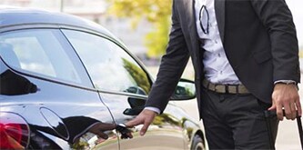 Ein Mann öffnet ein Auto 

