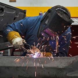 Sprühende Funken beim Zusammenschweißen von Metallwerkstücken in einer Fabrik