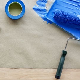 ScotchBlue™ Abdeckband neben einem Pinsel, der mit blauer Farbe bedeckt ist