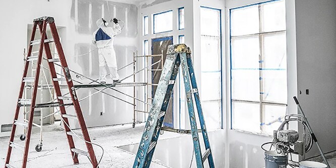 Professioneller Dekorateur auf einer Leiter - Wände streichen
