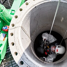 Ein Arbeiter, der einen 3M Helm trägt, in einem engen Raum