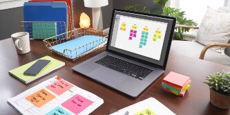  Ein Schreibtisch mit Laptop und vielen Post-it-Zetteln.
