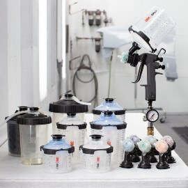 Alle Komponenten eines 3M Hochleistungslackierpistolen-Kits wie Düsen, Adapter